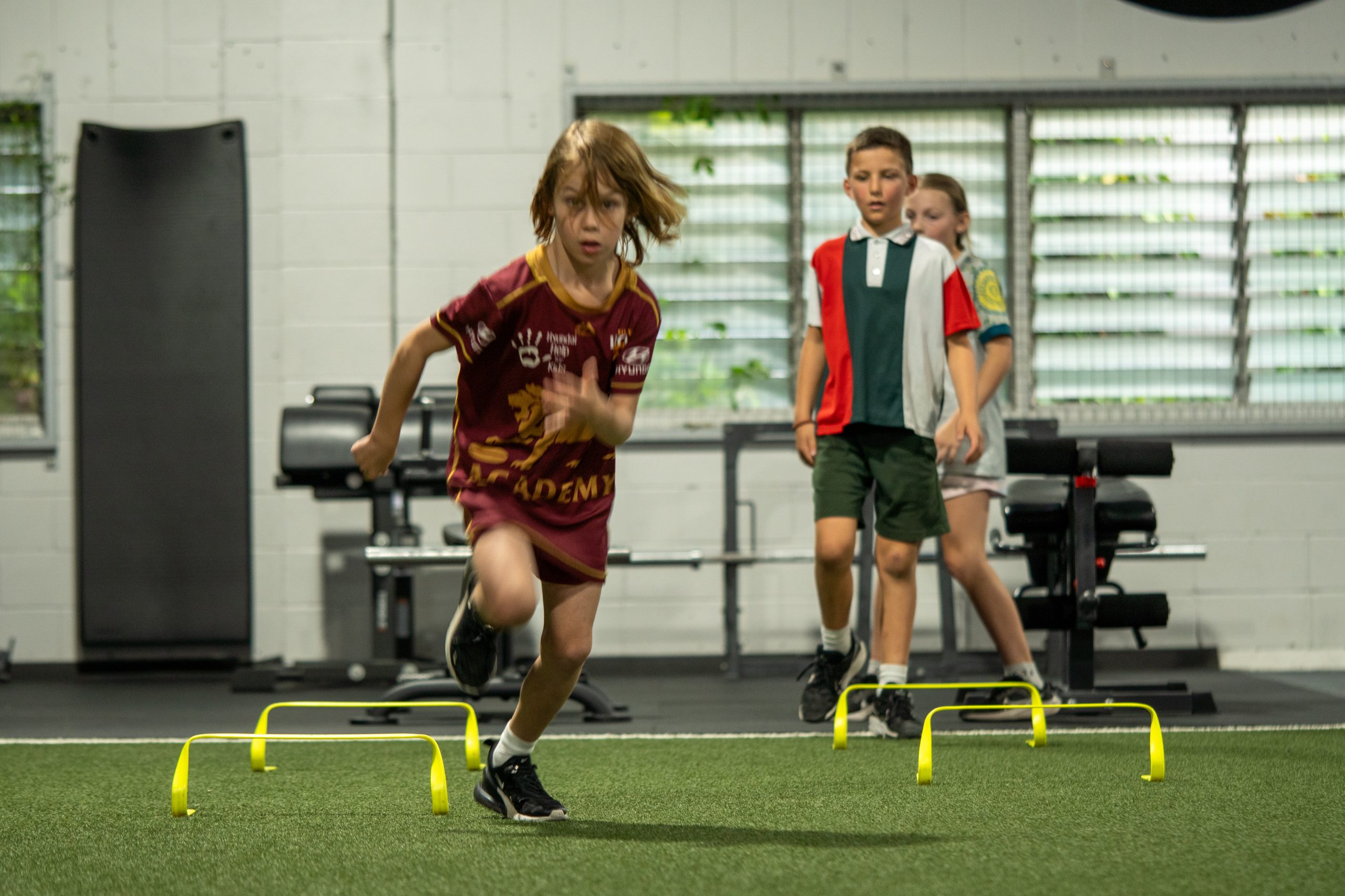 Youth Speed Foundation class at ATHLETIX Brisbane — kids sprinting with resistance bands