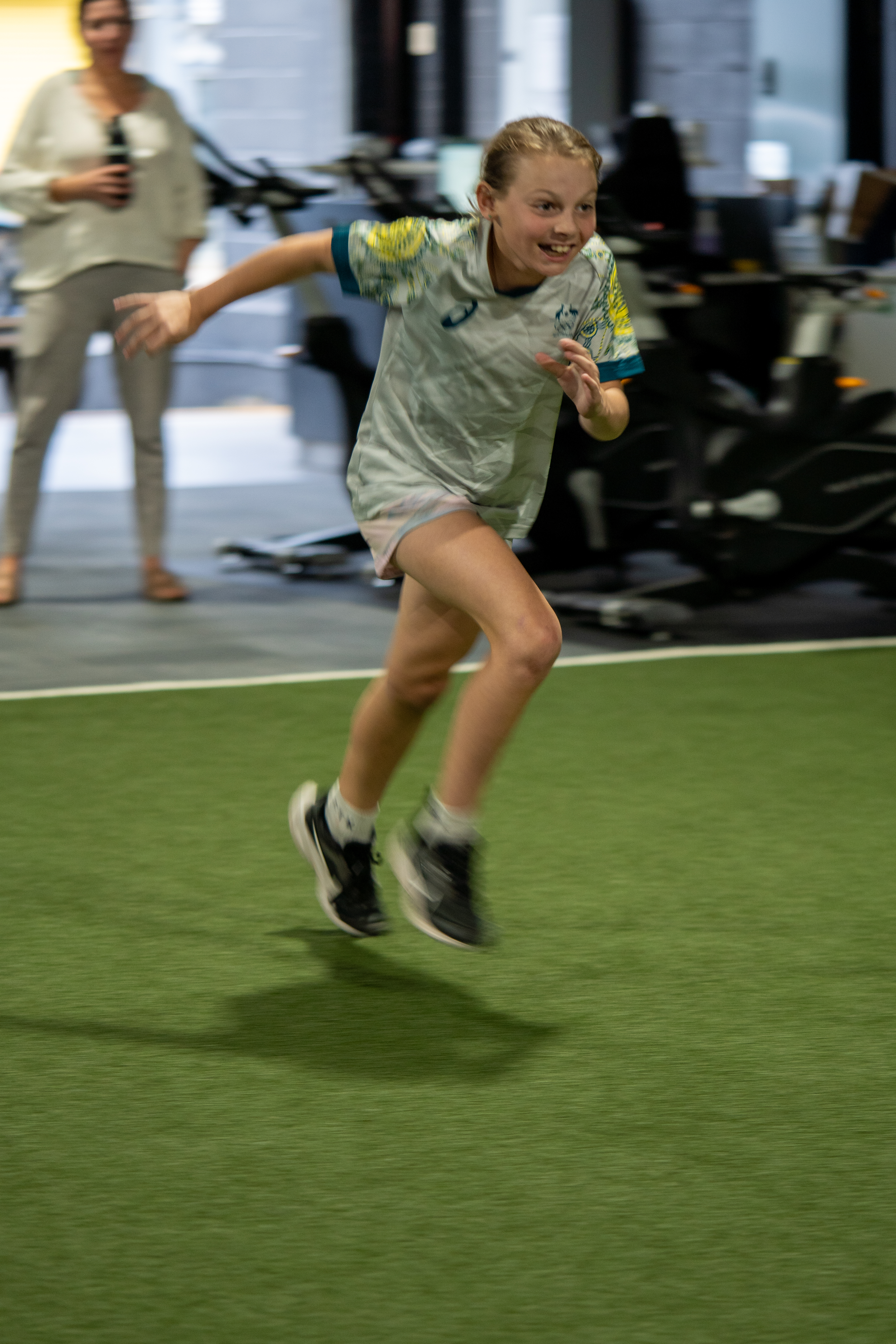 Athletes sled pushing under the ATHLETIC DEVELOPMENT wall at ATHLETIX Brisbane